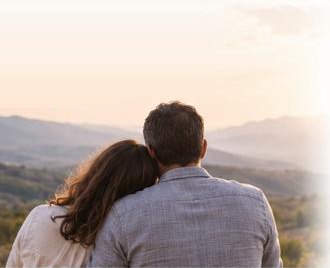 Pareja abrazada mirando el atardecer